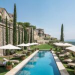 An idyllic setting for a luxury wedding in Provence, with a sparkling pool surrounded by verdant gardens and majestic cypress trees. This private estate is the ideal venue for a romantic ceremony, offering breathtaking views of the surrounding hills. With tailor-made organization, &#039;By Mademoiselle C&#039; transforms every celebration into a unique event, perfect for a grand celebration or dream wedding. Guests can relax under