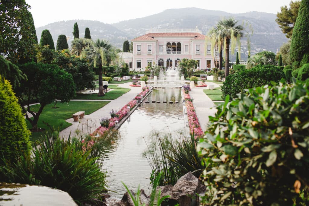 Un cadre romantique et élégant pour un mariage de luxe à Provence, Côte d'Azur et Corse, mettant en valeur un domaine privé exceptionnel. Ce jardin somptueux, avec ses fontaines et ses fleurs colorées, offre l'environnement parfait pour une célébration grandiose. La beauté naturelle des montagnes en arrière-plan crée une ambiance idéale pour un événement sur mesure, garantissant une expérience inoubliable pour un mariage de rêve. 'By Mademoiselle C' excelle dans l'organisation