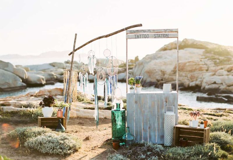An elegant and romantic corner for a luxury wedding in Corsica, featuring a handcrafted tattoo station, ideal for a unique celebration. With breathtaking sea views, this space is perfect for a bespoke ceremony, surrounded by natural landscapes. 'By Mademoiselle C' creates memorable events in exceptional locations, guaranteeing an unforgettable experience for a big day. Treat yourself to the wedding of your dreams, all