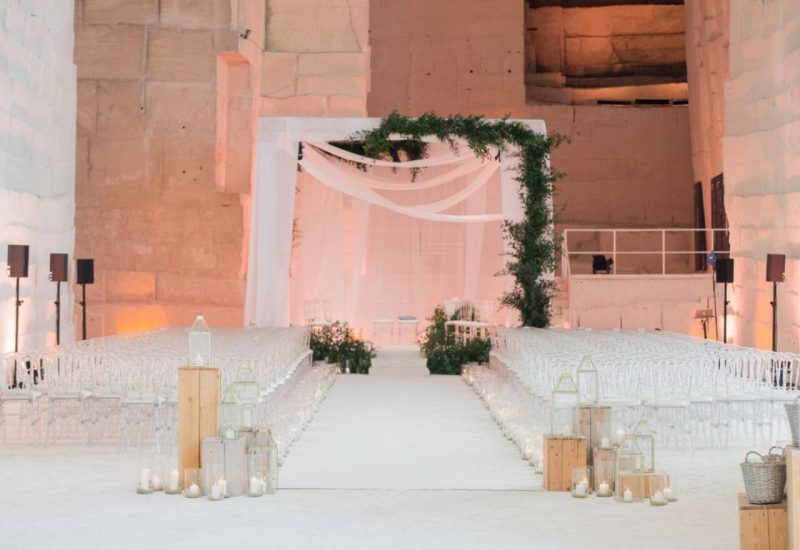 A romantic wedding ceremony on a private estate, showcasing the elegance and sophistication of a bespoke wedding. The aisles are adorned with delicate lanterns and candles, creating an intimate atmosphere for a grand celebration. This exceptional venue, ideal for a luxury wedding, offers a unique setting, perfect for an unforgettable event. With bespoke organization, 'By Mademoiselle C' transforms every moment into a dream,