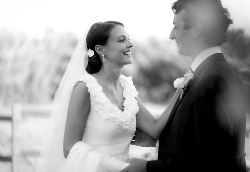 A radiant couple at their romantic wedding ceremony, organized by By Mademoiselle C, a luxury wedding planner in Provence, French Riviera and Corsica. The elegant, sophisticated atmosphere captures the essence of a bespoke event, while the picturesque surroundings evoke landscapes of vineyards and gardens. This scene illustrates a great moment of celebration, perfect for a dream wedding on a private estate.