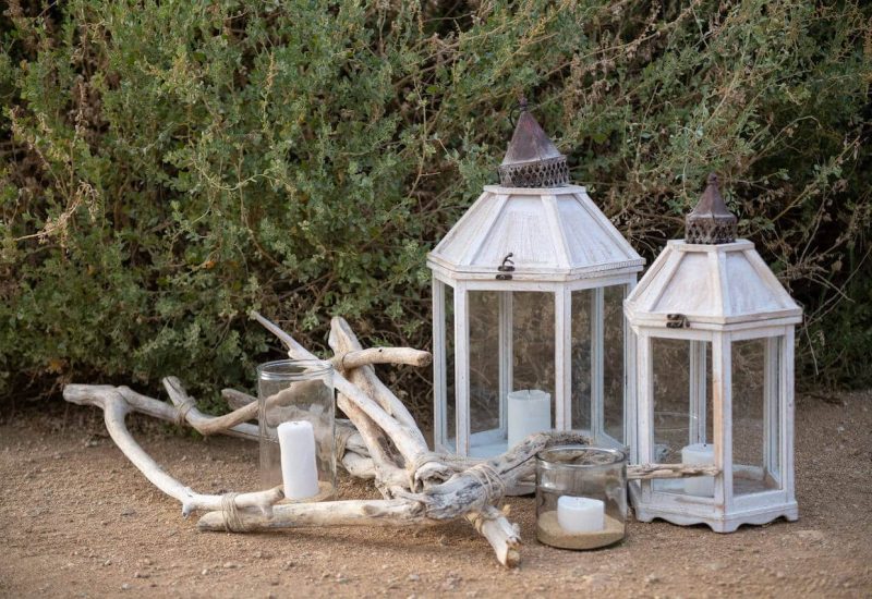 Lanternes élégantes en bois blanchi, accompagnées de bougies blanches, créant une atmosphère romantique pour un mariage de luxe en Provence. Parfaites pour une cérémonie sur mesure dans un domaine privé, ces éléments de décoration ajoutent une touche sophistiquée à un grand événement. Idéales pour un mariage de rêve, ces lanternes s'intègrent harmonieusement dans un jardin enchanteur, promettant une célébration unique et mémorable.