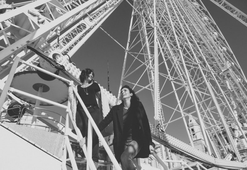Une scène romantique et élégante capturant un couple souriant s'élevant vers la grande roue, symbolisant une célébration unique. En tant que wedding planner de luxe en Provence, Côte d'Azur et Corse, By Mademoiselle C crée des mariages sur mesure dans des lieux exceptionnels. Cette image évoque la magie d'un événement grandiose, parfait pour un mariage de rêve, entouré par l'atmosphère vivante et sophistiquée du sud de la France.