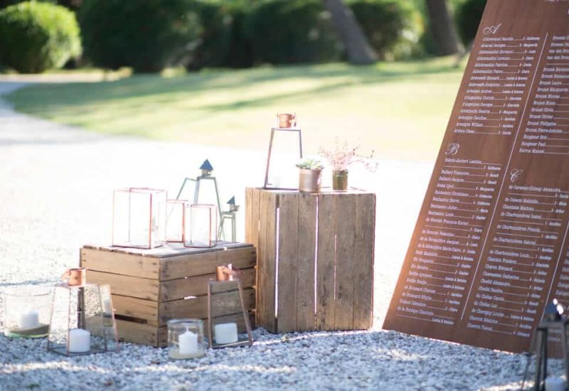 Un élégant coin de cérémonie de mariage, mettant en avant une décoration raffinée avec des lanternes et des éléments en bois, idéal pour un mariage romantique en Provence. Ce cadre enchanteur, entouré de verdure, évoque une ambiance sophistiquée pour une célébration grandiose. Avec l'expertise de By Mademoiselle C, chaque détail est soigneusement orchestré pour créer un événement unique dans un domaine privé, offrant un service de planification de mariage sur mesure pour