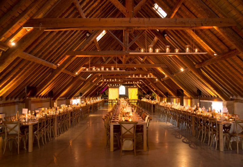 Salle de réception élégante et romantique, parfaite pour un grand mariage sur mesure. Les longues tables, ornées de bougies scintillantes, créent une ambiance chaleureuse et sophistiquée. Ce lieu d'exception, situé dans un domaine privé, offre un cadre idyllique pour une célébration grandiose. Idéal pour un mariage de luxe en Provence, Côte d'Azur et Corse, cet espace est conçu pour accueillir un événement unique et mémorable, alliant charme et raff