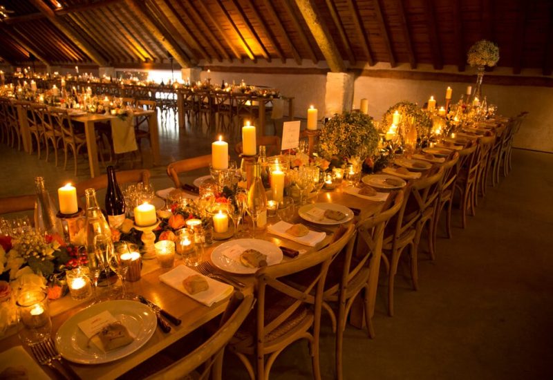 An elegantly set table for a grand wedding on a private estate, illuminated by candles creating a romantic atmosphere. This sophisticated space, ideal for a grand celebration, showcases By Mademoiselle C's expertise in planning luxury weddings in Provence, the French Riviera and Corsica. Every detail is carefully thought out for a tailor-made wedding experience, transforming this venue into a dream setting for a