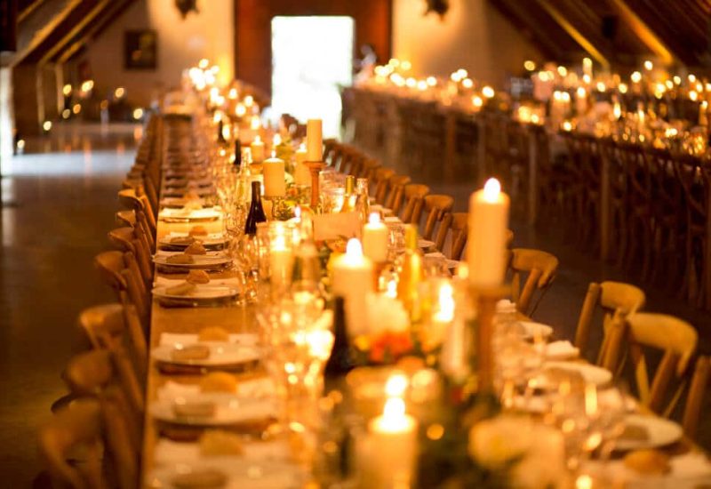Elegantly set table for a romantic wedding ceremony, illuminated by twinkling candles, on a private estate in Provence. This scene evokes a grand celebration and a unique event, perfectly orchestrated by By Mademoiselle C, the bespoke wedding specialist. The refined details and sophisticated atmosphere make this venue the ideal setting for a luxury wedding on the French Riviera or in Corsica, creating a