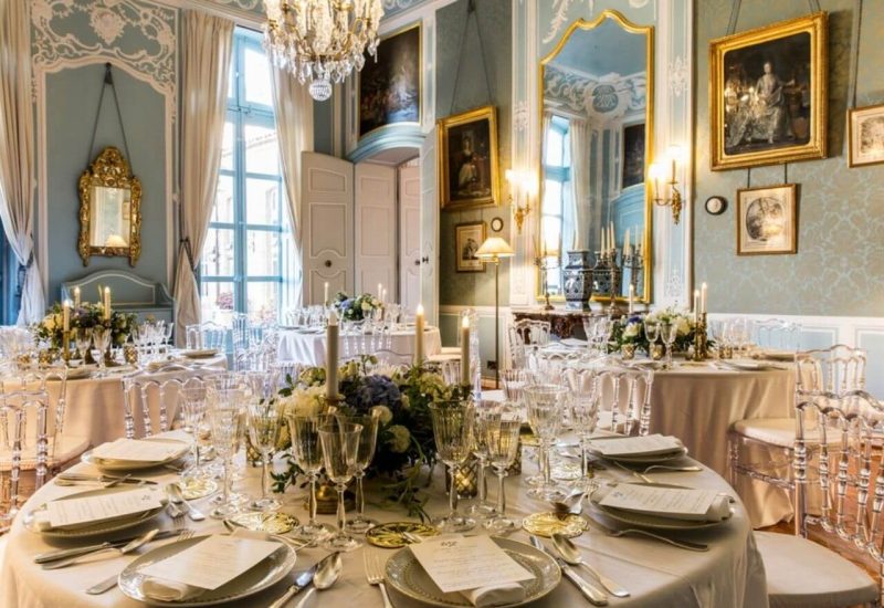 A magnificent reception hall for a romantic wedding, highlighting the elegance of a grand ceremony. Tables are carefully set with refined plates and sparkling glasses, creating a sophisticated ambience. Gilded chandeliers and antique mirrors add a touch of luxury, ideal for a bespoke event on a private estate in Provence. This exceptional setting is perfect for a memorable celebration, where every detail