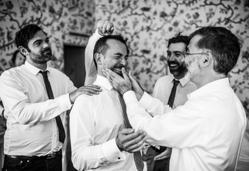 A joyful preparation for a luxury wedding, where friends laugh and help each other in an elegant atmosphere. This captured scene evokes the warm, romantic atmosphere of a grand event in a sophisticated setting, typical of bespoke weddings in Provence, the French Riviera and Corsica. By Mademoiselle C's expertise in organizing exceptional ceremonies is reflected in every detail, promising a unique celebration.