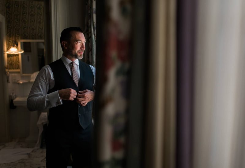 An elegant man preparing for his big day in a refined setting, symbolizing a luxury wedding in Provence, the French Riviera and Corsica. The romantic, sophisticated atmosphere evokes the tailor-made organization of an exceptional ceremony, ideal for a grandiose celebration. The meticulous details and chic surroundings highlight By Mademoiselle C's expertise in creating unique events, transforming every moment into a dream come true.