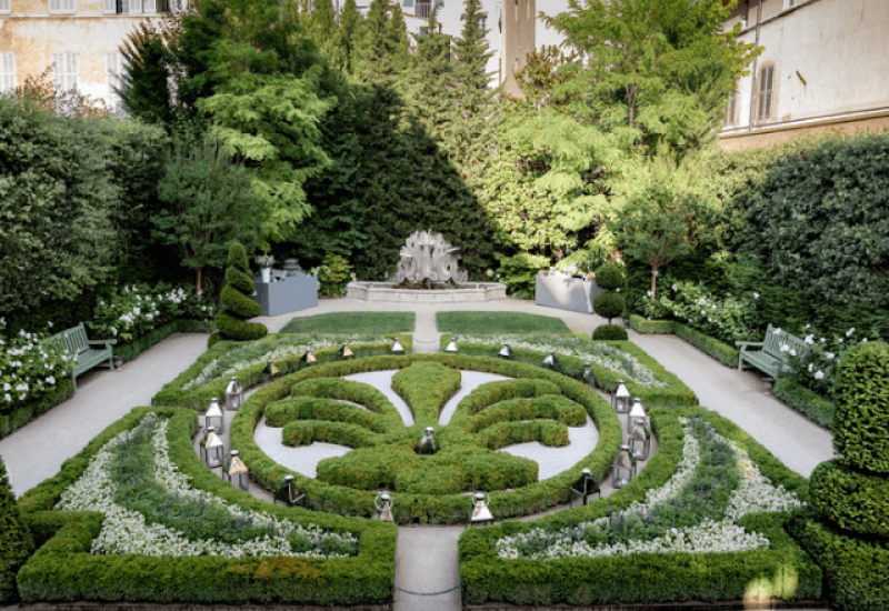 Elegant, romantic garden perfect for a bespoke wedding ceremony, organized by By Mademoiselle C. This exceptional venue, set on a private estate in Provence, evokes a grand celebration amid lush natural surroundings. Carefully tended flowerbeds and delicate lanterns create a sophisticated atmosphere, ideal for a dream wedding or unique event. The beauty of this garden highlights the expertise of our