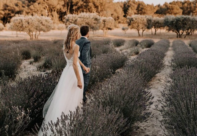 A couple strolling hand-in-hand through a lavender field in Provence, representing an ideal scene for a romantic wedding. This natural setting evokes the elegance of a grand ceremony, perfectly orchestrated by By Mademoiselle C, the specialist in luxury weddings in Provence, the French Riviera and Corsica. With a dream setting and exceptional venues, every event becomes a unique, made-to-measure celebration, creating unforgettable memories.
