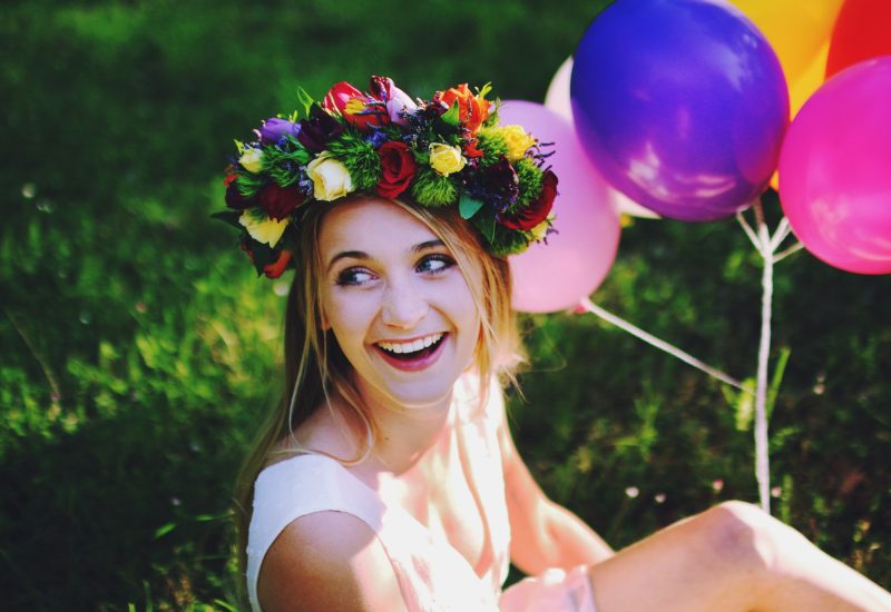 Une jeune mariée rayonnante, entourée de ballons colorés et d'une couronne de fleurs, incarne l'élégance et la joie d'un mariage romantique. Ce moment capturé évoque la magie d'un événement sur mesure, parfaitement organisé par 'By Mademoiselle C', votre wedding planner de luxe en Provence, Côte d'Azur et Corse. Avec des décors naturels enchanteurs, tels que des jardins luxuriants, chaque mariage devient une célébration.