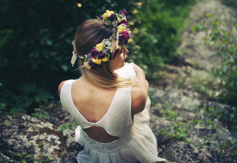 An elegant bride, wearing a crown of flowers, stands in a verdant setting, symbolizing the magic of a romantic wedding. This image evokes By Mademoiselle C's expertise as a wedding planner in Provence, the French Riviera and Corsica, specializing in the organization of luxury celebrations. The natural setting, typical of made-to-measure events, highlights elements of sophistication and charm, perfect for a ceremony.
