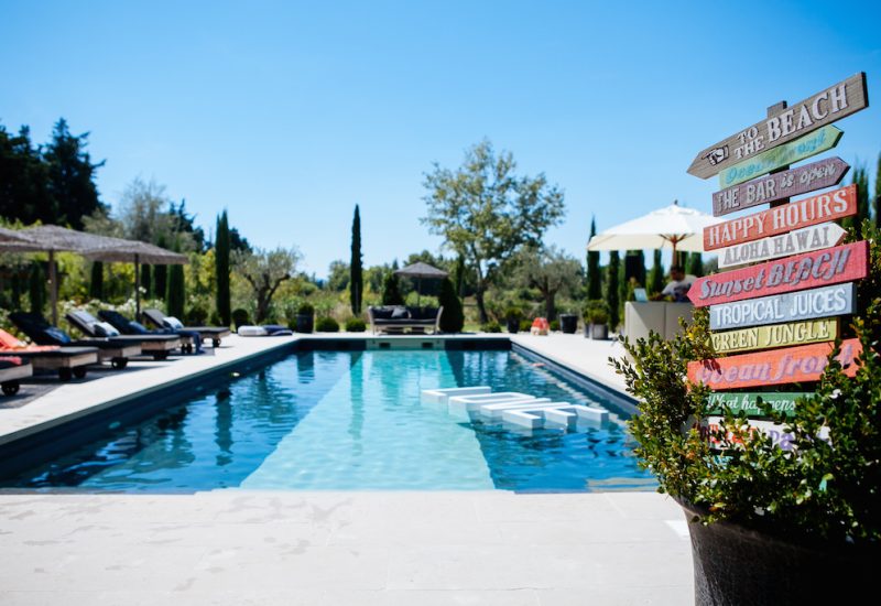A luxurious pool surrounded by elegant loungers and greenery, ideal for a romantic wedding on a private estate in Provence. This sophisticated setting represents an exceptional venue for a grand celebration, where every detail is carefully organized by By Mademoiselle C. Offering a dreamy atmosphere, this space is perfect for a bespoke ceremony, surrounded by enchanting landscapes, creating a unique and memorable event.