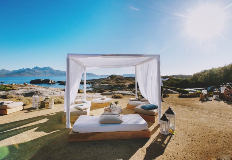A romantic, elegant space for a luxury seaside wedding ceremony, offering breathtaking views of the mountains and ocean. This setting on a private estate evokes a grand celebration, perfect for a bespoke event. Comfortable cushions and lanterns add a touch of sophistication to this idyllic scene, ideal for a unique wedding in Provence, the French Riviera and Corsica. By Mademoiselle C makes every dream come true.