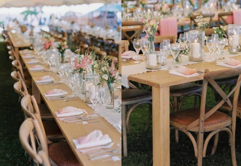Tables elegantly set under a marquee, creating a romantic atmosphere for a grand event. This scene evokes a bespoke wedding celebration, with delicate floral decorations and candles, perfect for a luxury wedding in Provence, French Riviera and Corsica. Every detail is carefully organized to offer a unique and exceptional experience, ideal for a grand ceremony on a private estate. The elegance of the wooden tables and