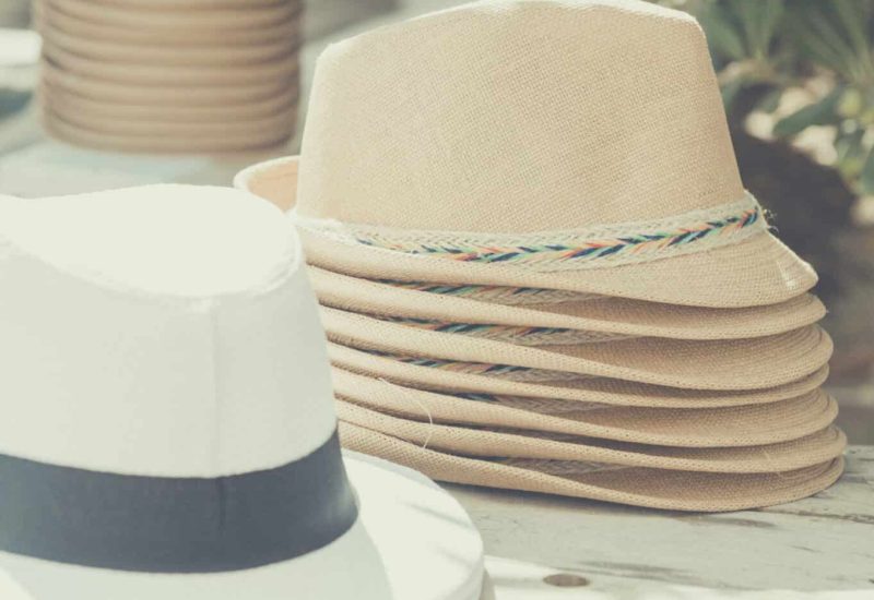 Elegant hats set on a wooden table, evoking the romantic, sophisticated ambience of a bespoke wedding in Provence, the French Riviera and Corsica. Perfect for a grand ceremony or unique celebration, these accessories add a touch of luxury to an event on a private estate or in an exceptional setting. Ideal for a dream wedding, every detail is carefully organized to create an unforgettable experience.