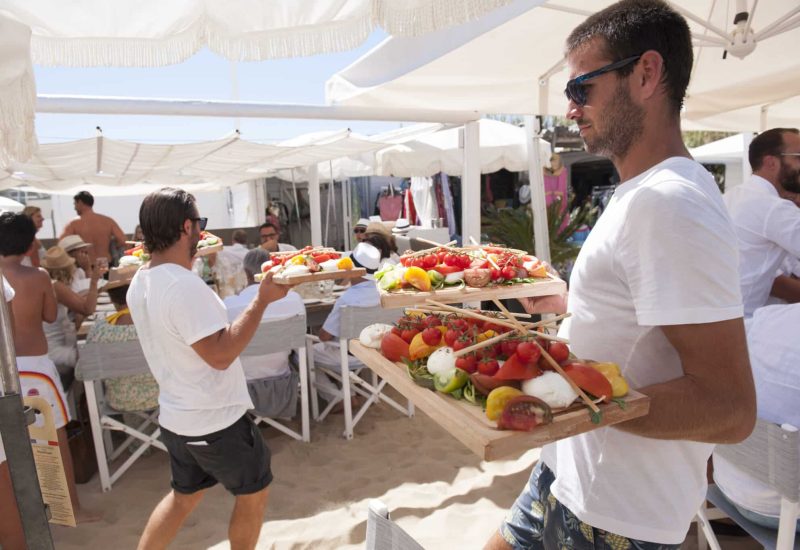 Elegant catering at a luxury beach wedding, showcasing refined and colorful dishes. This romantic and sophisticated scene captures the essence of a bespoke celebration in an idyllic setting, typical of the exceptional events organized by By Mademoiselle C. Guests enjoy a great moment of conviviality, surrounded by the natural beauty of the French Riviera. This type of organization on a private estate