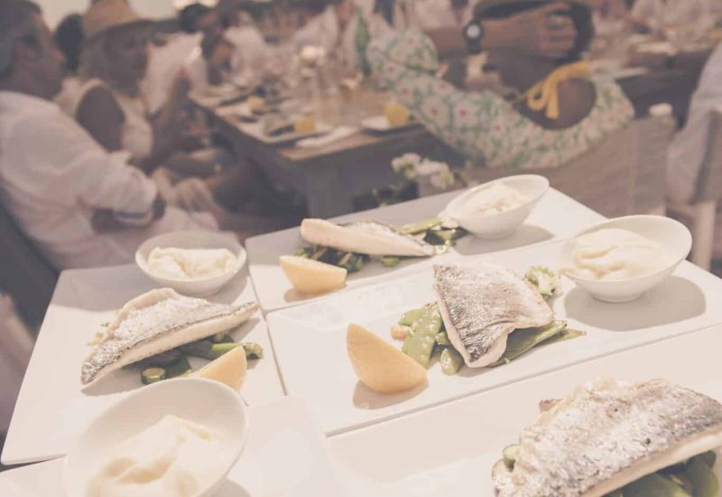 A sumptuous open-air wedding dinner, organized by By Mademoiselle C, showcases refined gastronomy in a unique celebration. The exquisite dishes, elegantly presented, illustrate the expertise of our bespoke wedding planning in Provence, the French Riviera and Corsica. The romantic, sophisticated atmosphere, surrounded by white-robed guests, creates the perfect setting for a grand ceremony. This moment