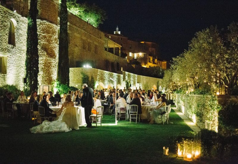 A magnificent outdoor wedding reception, organized by By Mademoiselle C, takes place on a private estate in Provence. Surrounded by soft lights and a romantic atmosphere, guests enjoy a grand banquet under the stars. This luxurious wedding, with its elegantly laid tables, underlines the sophistication of a made-to-measure celebration. The enchanting setting, with its lush gardens and ancient stonework, makes it an ideal venue.