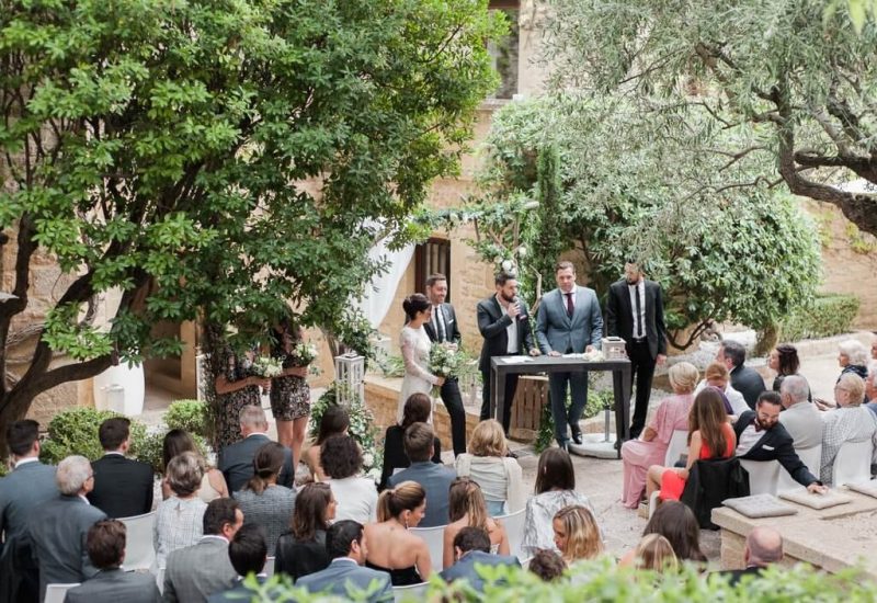 Cérémonie romantique en plein air dans un jardin élégant, mettant en valeur l'expertise de By Mademoiselle C en tant que wedding planner de luxe en Provence, Côte d'Azur et Corse. Les invités, habillés avec soin, assistent à un grand moment de célébration, entourés par un cadre verdoyant et des éléments de décoration sur mesure. Cette organisation de mariage sur un domaine privé incarne une expérience de mariage unique et sophistiquée, idéale pour un