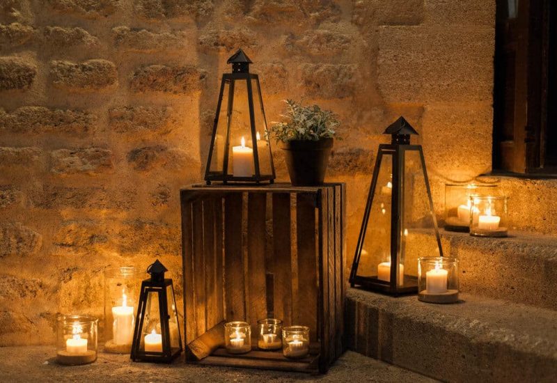 Ambiance romantique et élégante d'un mariage de luxe, mettant en avant des lanternes en fer et des bougies créant une atmosphère chaleureuse dans un domaine privé. Cette scène évoque une célébration grandiose et sur mesure, idéale pour un événement unique en Provence, Côte d'Azur ou en Corse. Le cadre sophistiqué, avec des éléments naturels et une lumière douce, est parfait pour un mariage de rêve, soulignant l'expertise de By Mademoiselle C