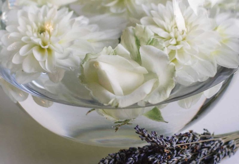 Fleurs blanches éclatantes flottant dans un vase élégant, accompagnées d'une touche de lavande, créent une ambiance romantique et sophistiquée, parfaite pour un mariage de luxe en Provence. Ce décor délicat évoque une célébration sur mesure dans un domaine privé, où chaque détail est conçu pour un événement unique. Imaginez une cérémonie grandiose au milieu des vignobles en fleurs, offrant un cadre exceptionnel pour un rêve devenu réalité. La marque 'By Mademoiselle C'