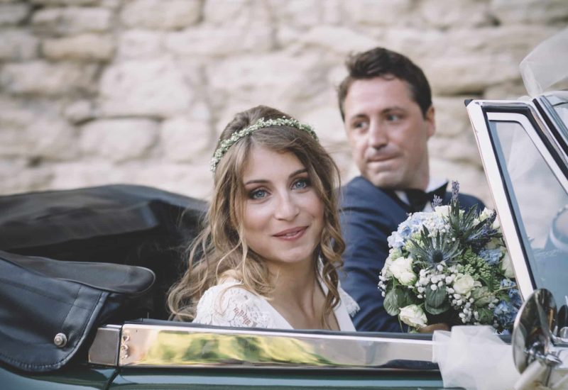 Une magnifique mariée souriante dans une voiture de luxe, entourée d'un cadre romantique et élégant, symbole d'un mariage sur mesure en Provence. Avec des éléments de décoration florale délicate, elle incarne la magie d'une cérémonie grandiose dans un domaine privé. Ce moment capture l'essence d'une célébration unique, idéale pour un mariage de rêve sur la Côte d'Azur ou en Corse, où chaque détail est soigneusement orchestré pour créer une expérience inoubliable.
