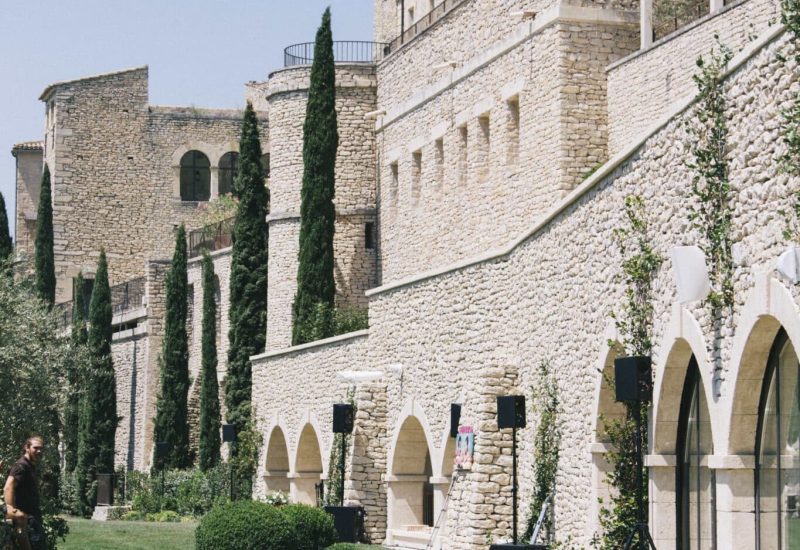 Un cadre élégant et romantique pour un mariage de luxe à By Mademoiselle C, mettant en avant un domaine privé en Provence. La façade en pierre de cet exceptionnel lieu de célébration s'intègre parfaitement dans le paysage verdoyant, créant une atmosphère sophistiquée pour une cérémonie grandiose. Ce cadre idyllique est idéal pour une organisation de mariage sur mesure, où chaque détail est pensé pour réaliser le rêve d'un événement unique et mémorable.