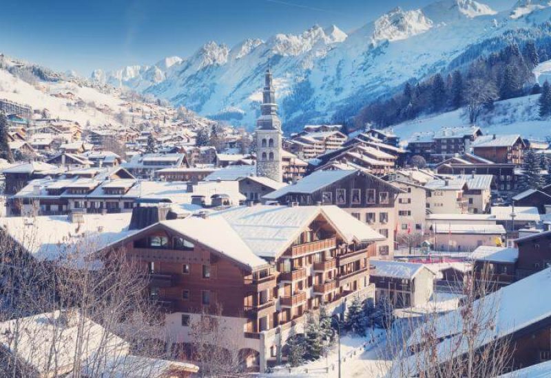 Une vue panoramique d'un village pittoresque, enveloppé dans un manteau de neige, évoquant une ambiance romantique et sophistiquée, idéale pour un **grand événement**. Ce **domaine privé** offre un cadre exceptionnel pour une **célébration grandiose** en hiver. Les montagnes majestueuses en arrière-plan soulignent le caractère unique d'un **mariage de luxe**. L'atmosphère élégante et chaleureuse est parfaite pour une **c