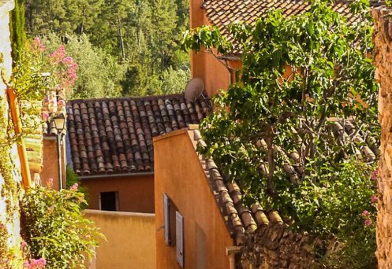 Un charmant chemin sinueux bordé de maisons provençales colorées, idéal pour une cérémonie de mariage romantique. Ce paysage pittoresque, entouré de verdure luxuriante et de collines, évoque l'élégance d'une célébration grandiose. En tant que planificateur de mariage de luxe en Provence, Côte d'Azur et Corse, By Mademoiselle C crée des événements sur mesure dans des lieux exceptionnels comme ce domaine privé.