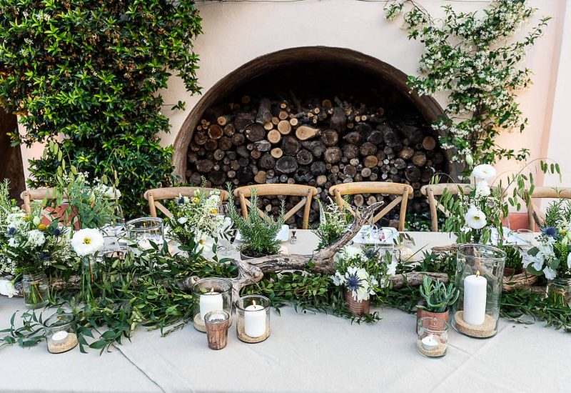 An elegant reception table for a luxury wedding in Provence, adorned with delicate flowers and lush greenery, evokes a romantic and sophisticated atmosphere. This enchanting setting, ideal for a grandiose celebration, showcases By Mademoiselle C's expertise in organizing tailor-made weddings. Sparkling candles and refined details create a warm ambience, perfect for a unique event in